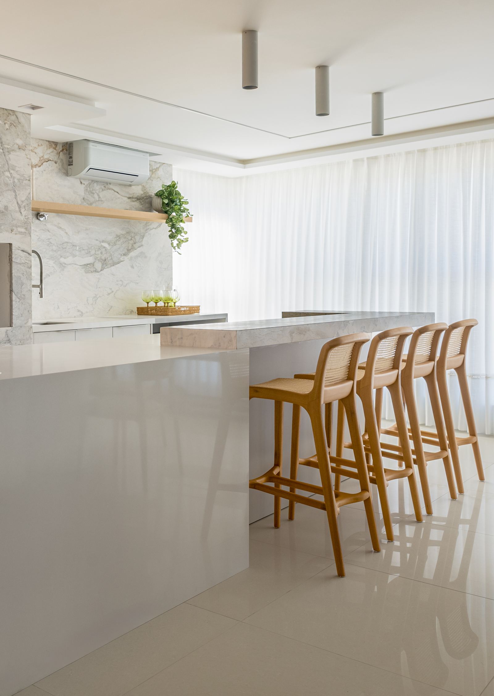 Living com cortinas leves e luz do mar